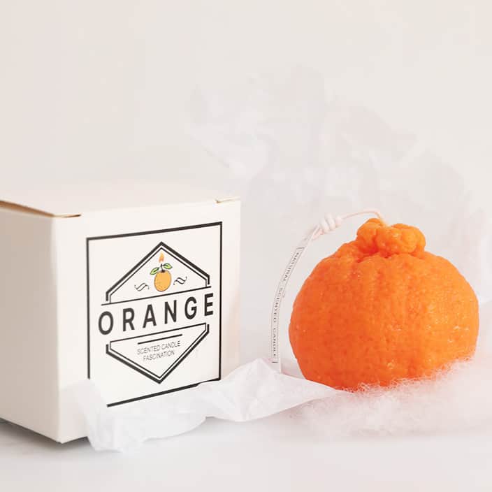 Ароматна свещ - портокал седи на върха на кутия.