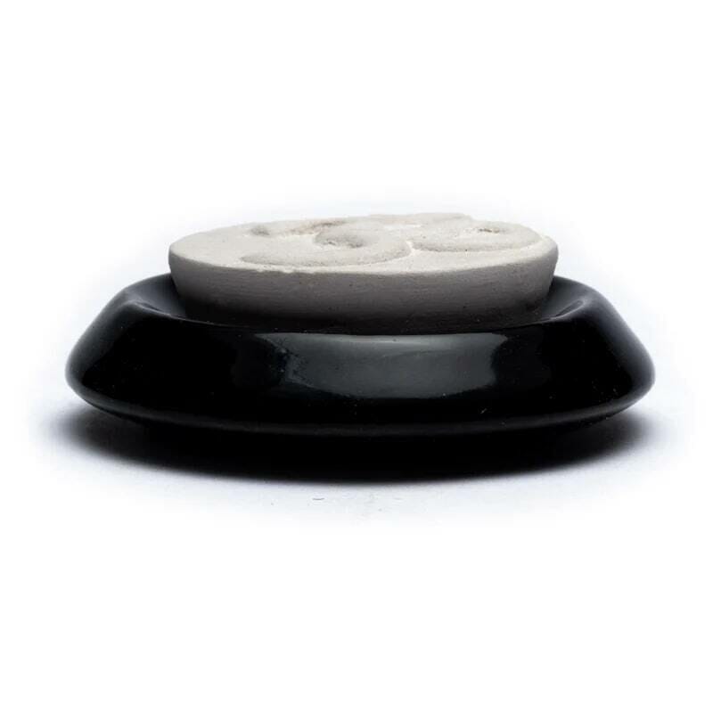Черно-бял Арома дифузер - ароматен камък OHM върху бяла повърхност.