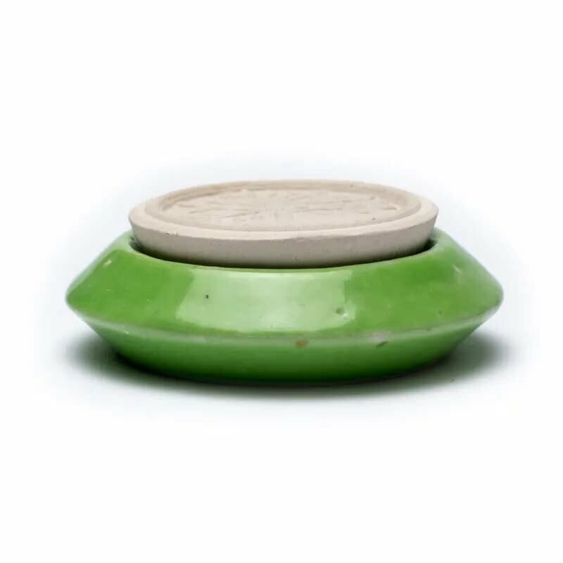 A green Aroma difuser - ароматен камък Дървото на живота with a white lid on top.