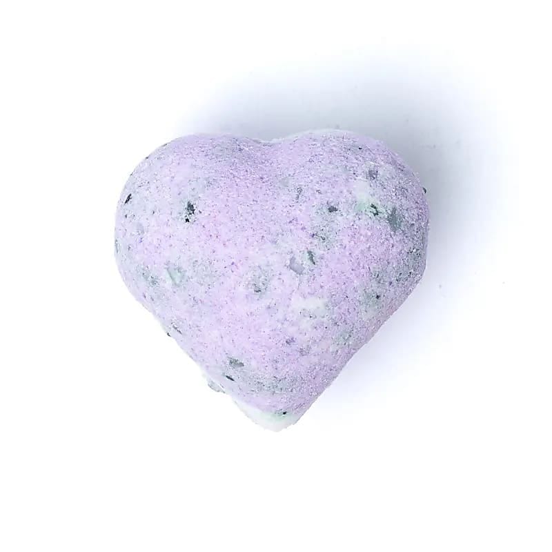 Бомбичка за баня във форма на лилаво сърце, наречена "Бомбичка за вана с аромат на Пачули" на бял фон.